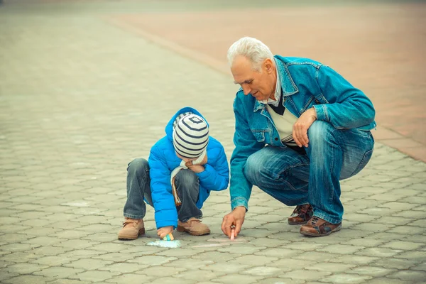 Grandfather and grandson draw with chalks — Stock Photo, Image