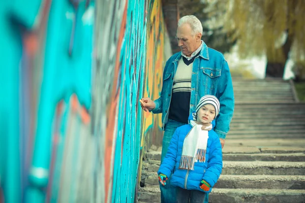 Дедушка и внук рисуют граффити — стоковое фото