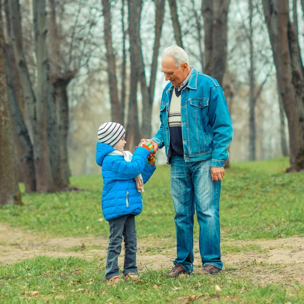 Дедушка показывает внуку винтажные часы — стоковое фото