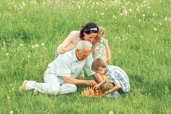 Großvater spielt Schach mit Enkeln und Tochter — Stockfoto