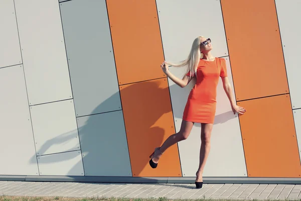 Modemädchen in Sonnenbrille und orangefarbenem Kleid — Stockfoto