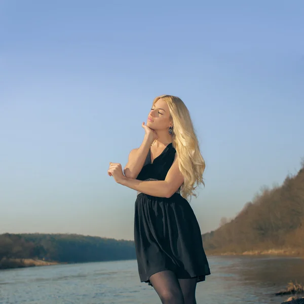 Mädchen am Strand im schwarzen Kleid — Stockfoto