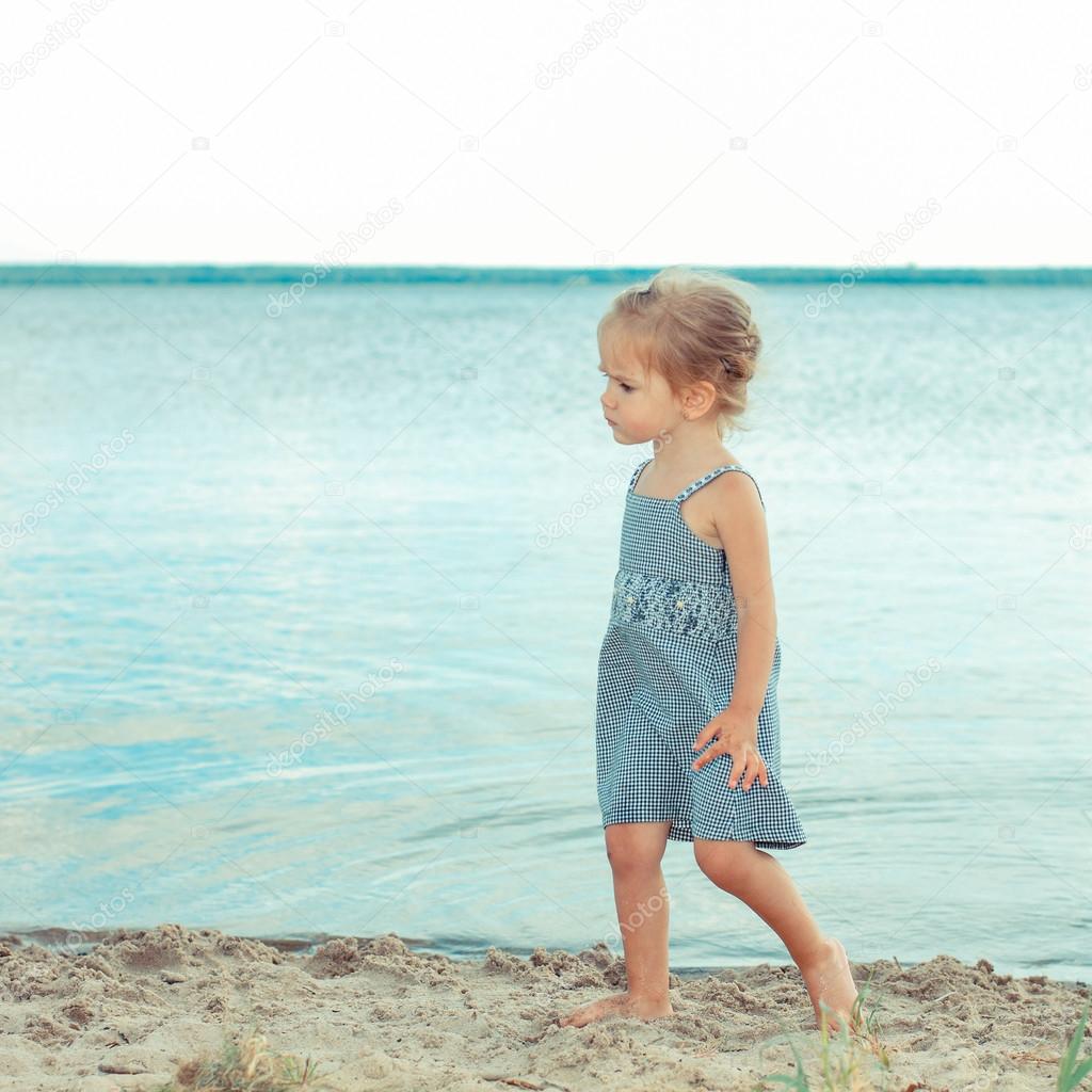 little girl standing on the beach