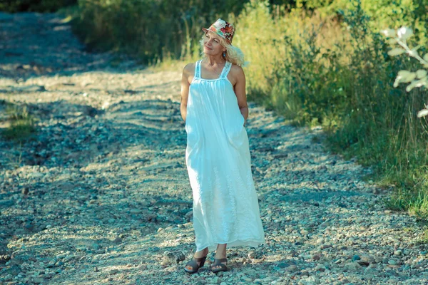 Senior woman standing on a precipice — Stock Photo, Image