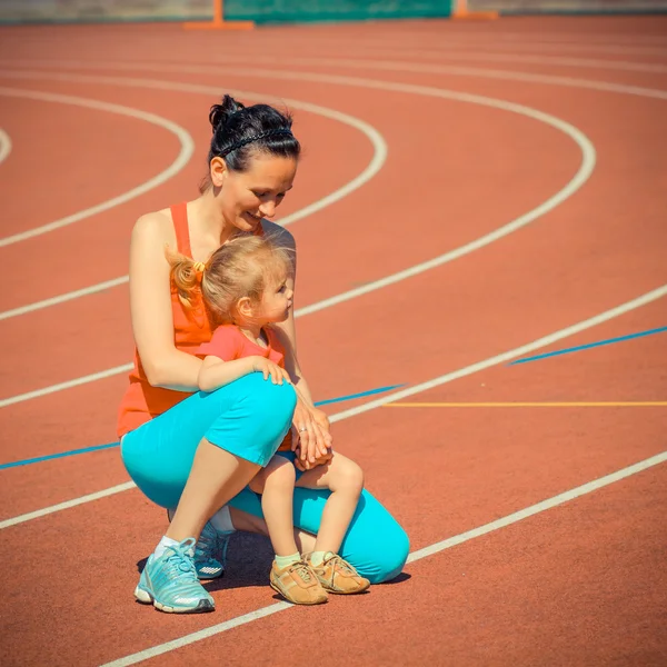 Спортивная подготовка матери и дочери на стадионе — стоковое фото