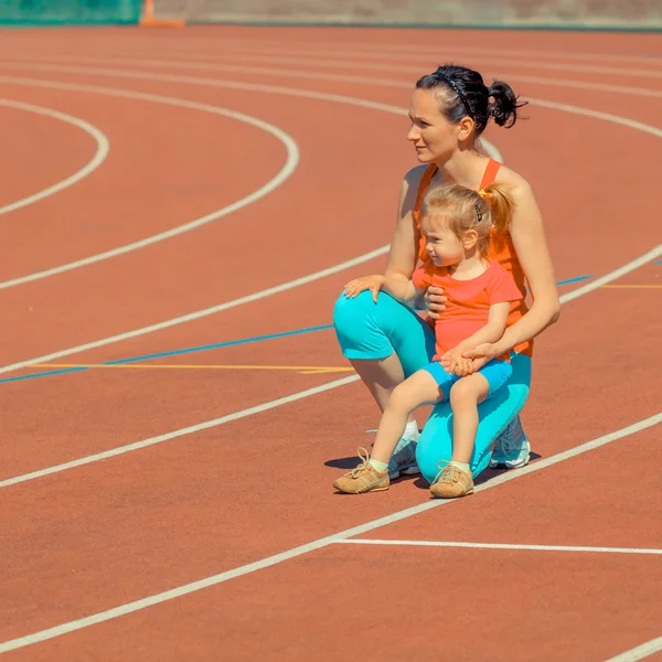Спортивная подготовка матери и дочери на стадионе — стоковое фото