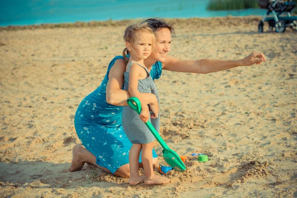 Mère avec sa fille jouant avec le sable — Photo