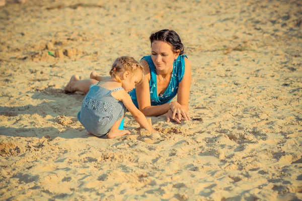 Mãe com criança brincando com areia — Fotografia de Stock