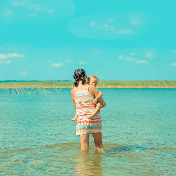 Maman et petite fille debout dans l'eau — Photo