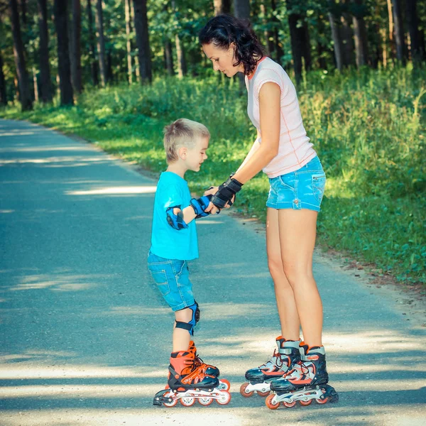 Moeder en zoon leren te rolschaatsen — Stockfoto