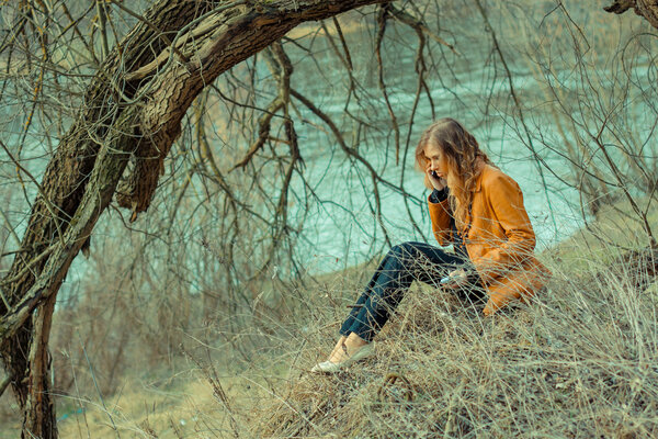 Portrait of a beautiful girl in the park in spring. Hipster girl in depression