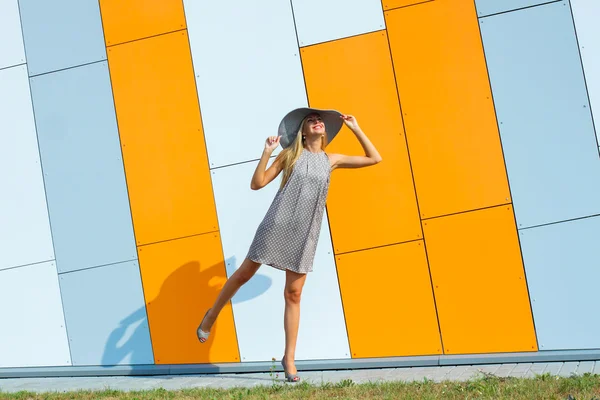 Flicka i en ljus klänning och en lång ihålig hatt — Stockfoto