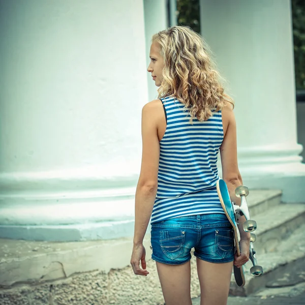 Hipster meisje met skateboard — Stockfoto