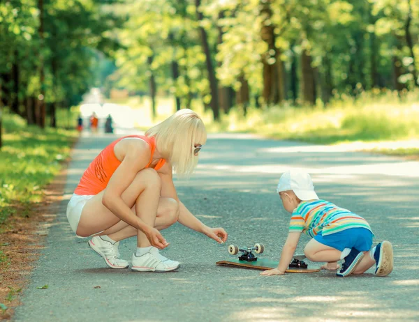 Ragazzo con madre riparazione bordo — Foto Stock