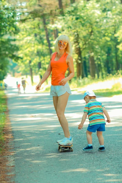 Mère et fils s'amusent avec le skateboard — Photo