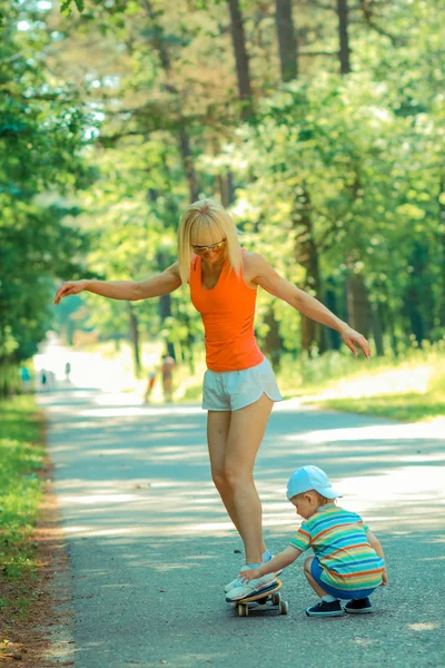 Mère et fils s'amusent avec le skateboard — Photo
