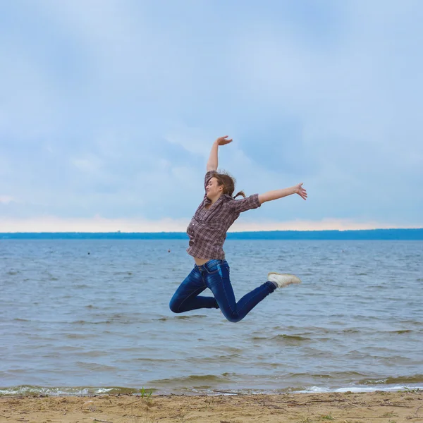 Meisje springt op het strand — Stockfoto