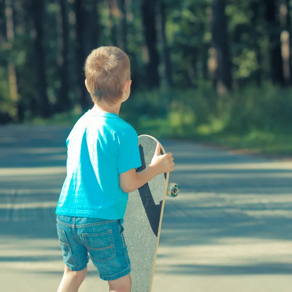 Petit garçon avec planche à roulettes — Photo