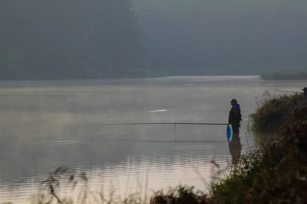 Un pescador captura un pez — Foto de Stock