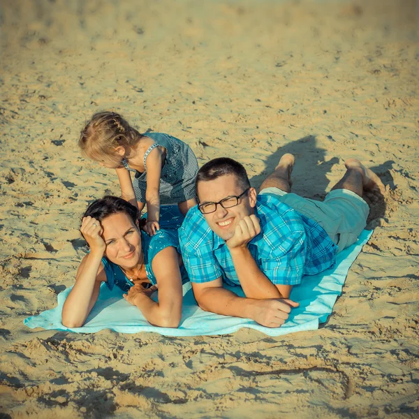 Família deitada na praia — Fotografia de Stock