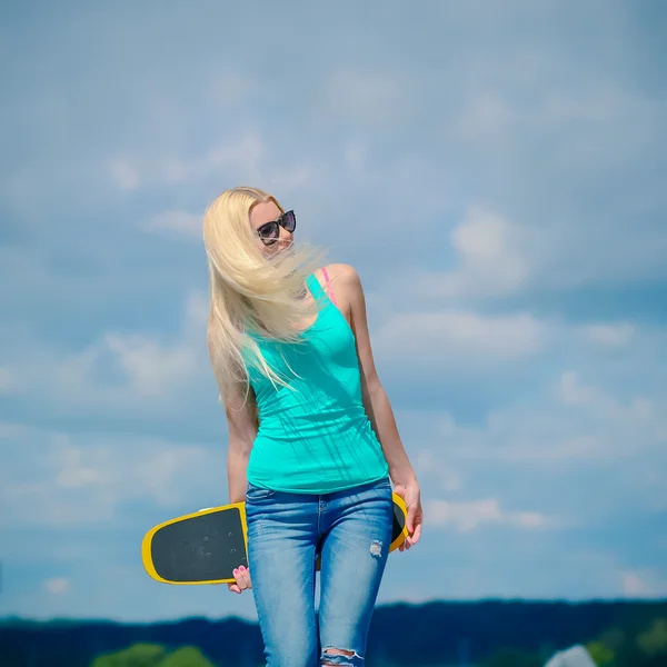 Flicka i jacka med skateboard — Stockfoto