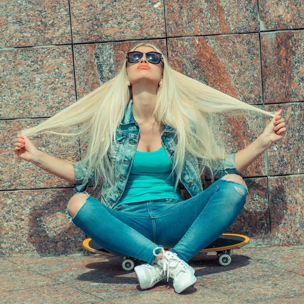 Girl sitting on a skateboard — Stock Photo, Image