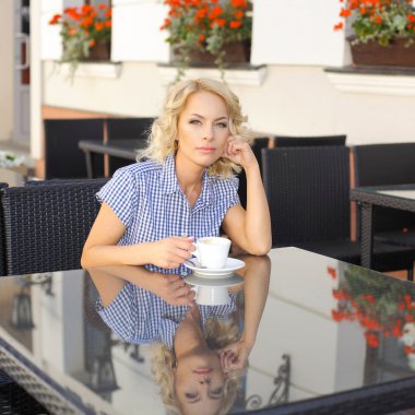 bir fincan kahve ile oturan kız