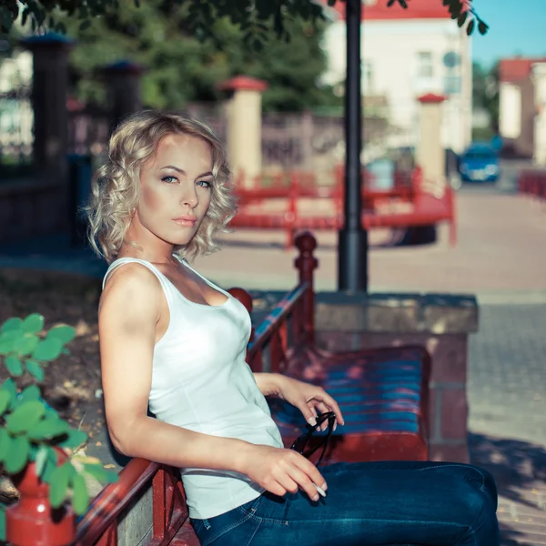 Žena na lavici a kouřit doutník — Stock fotografie
