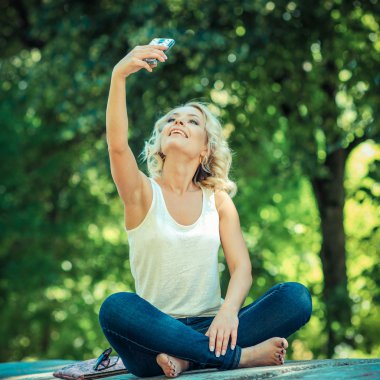 charming blonde posing with smartphone