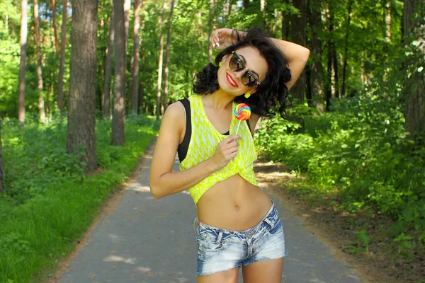 Fashion girl posing with lollipop — Stock Photo, Image