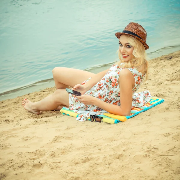 Женщина на пляже со смартфоном — стоковое фото