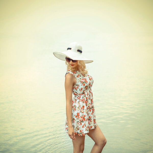 girl in hat in sunglasses on beach