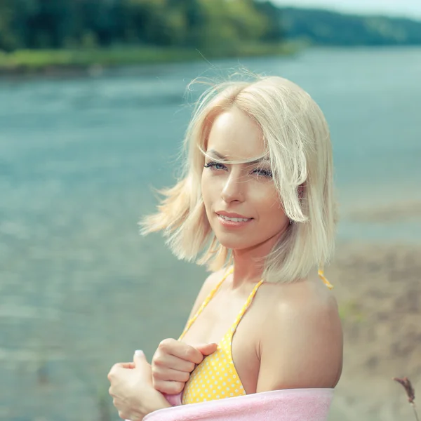 Vrouw in gele bikini en handdoek — Stockfoto