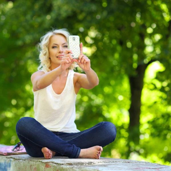 Affascinante bionda in posa con smartphone — Foto Stock