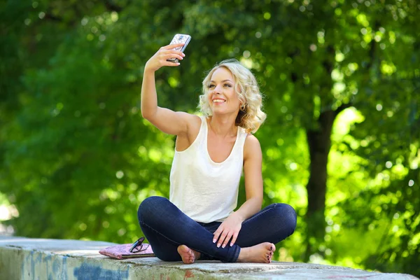 Encantadora rubia posando con smartphone —  Fotos de Stock