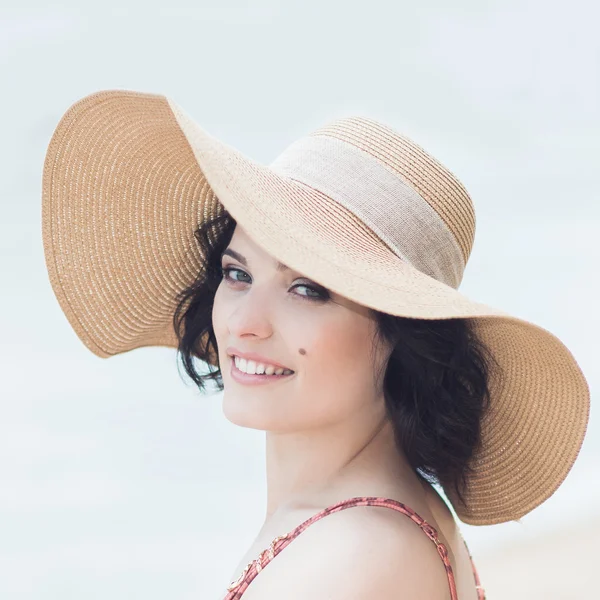Woman in straw hat on beach — Stock Photo, Image