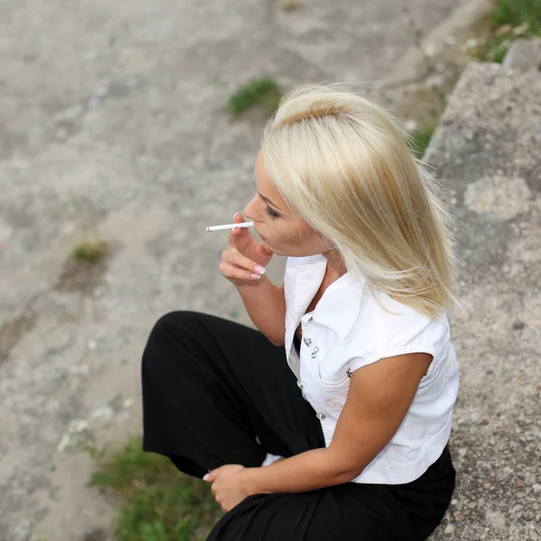 Модная блондинка, курящая сигареты — стоковое фото