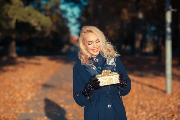Szczęśliwa kobieta z prezent w parku jesień — Zdjęcie stockowe