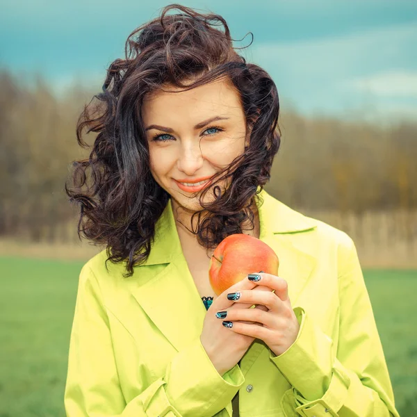 Ung kvinna med äpple, utomhus — Stockfoto