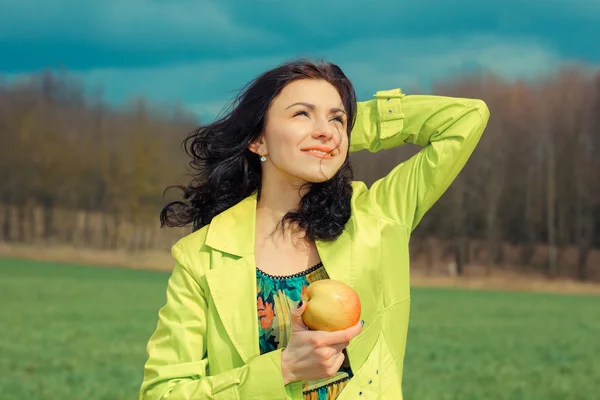 Young woman holding apple, outdoors — Stock Photo, Image