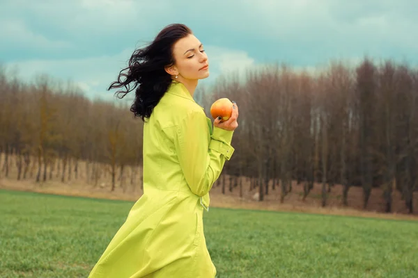 Молодая женщина держит яблоко на открытом воздухе — стоковое фото