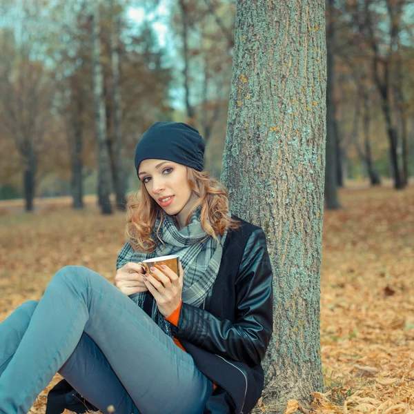 Mujer con taza de café en el parque de otoño — Foto de Stock