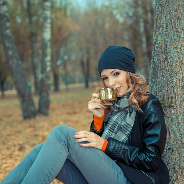 Mulher com xícara de café no parque de outono — Fotografia de Stock