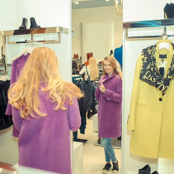 Flickan att välja kläder i en boutique — Stockfoto