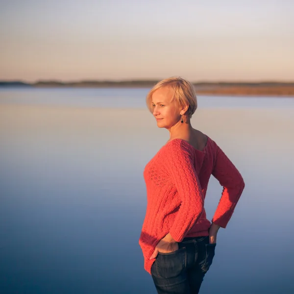 Achterkant van het meisje tegenover het meer — Stockfoto