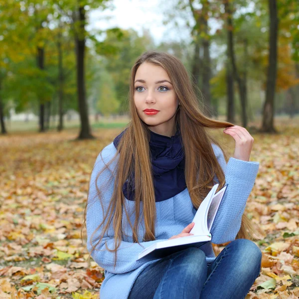 Flicka läsa en bok utomhus — Stockfoto