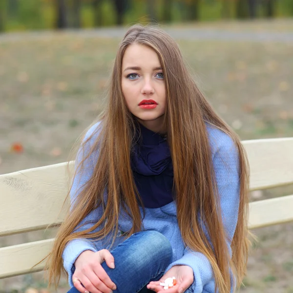 Menina triste com pílulas ao ar livre — Fotografia de Stock