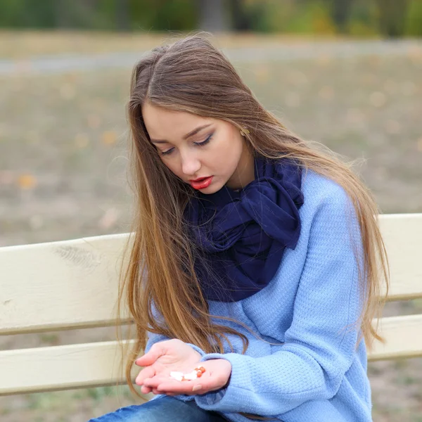 Ragazza triste con pillole all'aperto — Foto Stock