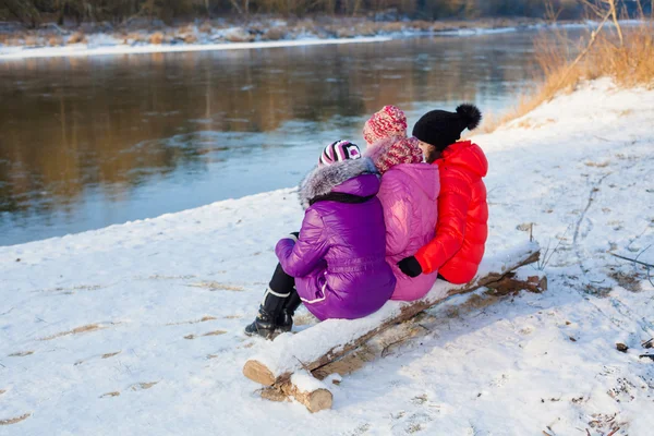 Mother and  daughters sitting on the bank — Stock Photo, Image