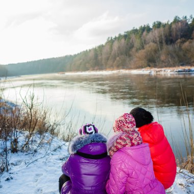 Anne ve kızı kıyıda oturan